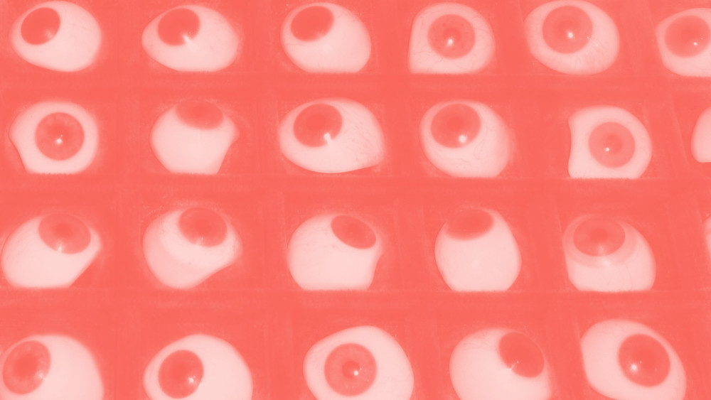 Array of glass eyes with a semi-transparent salmon-coloured overlay.